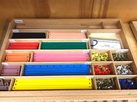 tray holding colored wooden sticks, brads, cards