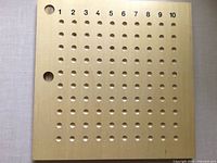 Square wooden board showing 10×10 grid and top row numbers 1-10