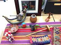 Overall view of textiles, figurines, ceramics, gourd, spindle, ocarina, cross and framed print