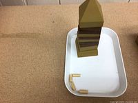 Assembled obelisk puzzle on tray with several loose pieces