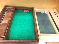 Overall view of two felt-lined compartments, numbered tiles and dice visible