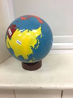 Full view of globe showing Asia continent, mounted on brown base