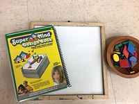 Cover of SuperMind Design Book, whiteboard, wood bowl with coloured tiles