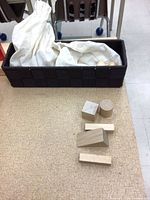 Wooden shapes on table beside basket and fabric bag visible