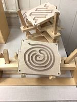 Two maze boards on support frame showing spiral and wave patterns