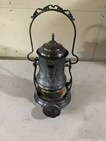 Front view of silver plated Victorian tilting ice-water pitcher on stand