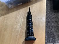 Full view of the argillite totem pole on wooden surface