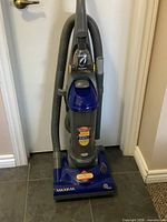 Full view of Eureka Maxima upright vacuum with hose and attachments