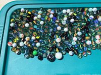 Wide view of assorted marbles spread on tray showing quantity and variety