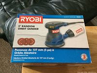 Front of boxed Ryobi 5" random orbit sander showing branding and size