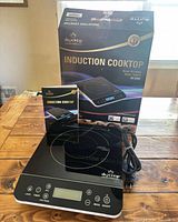 Cooktop, manual and box on table