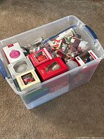 Plastic tote containing numerous boxed ornaments
