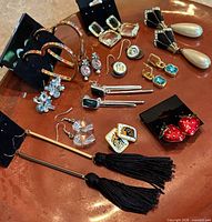 All 12 pairs of earrings laid out on surface