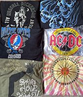All six folded T-shirts showing front graphics