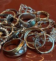 Pile of mixed rings showing metal finishes and stone accents