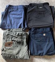 Four pairs of folded shorts showing colors and brands