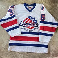 Front view of jersey showing logo, stripes, numbers, collar tag