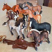 Group of eight model horses with tack pieces