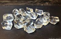 Group of clear acrylic ice rock pieces on dark background