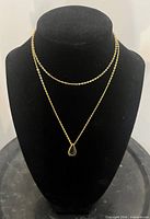 Full view of gold-plated chain necklace on bust form showing pendant placement