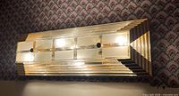 Front angled view showing brass frame, glass panels and lit bulbs
