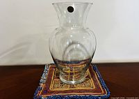 Full view of clear crystal vase on fabric mat