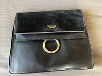Front view showing GUESS logo plaque and gold ring hardware