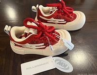 Left and right sneakers side view with tags showing brand label