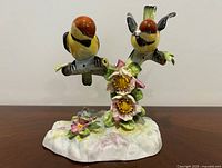 Front view of twin bird bone china figurine on floral branch