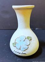 Front view of vase showing flower motif and artist signature