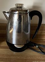 Full view of stainless steel Farberware percolator showing handle, lid with glass knob and power cord
