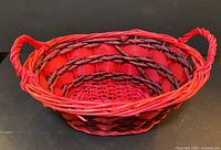 Front view showing oval shape, red and brown weave, twin handles