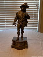 Front view of bronze-finish musketeer figurine on pedestal base