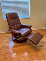 Recliner shown fully extended with footrest, swivel base visible
