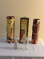 Group shot of all three wine boxes and two glass bottles on table