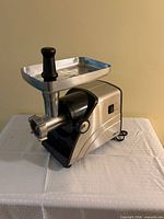 Front view of Deni meat grinder with tray and pusher attached