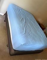 Memory foam mattress with sheet atop box spring on frame