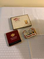 All three tins grouped on cloth surface