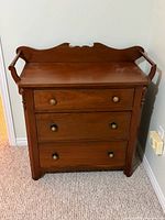 Front view of solid wood 3-drawer chest showing backsplash, side rails, brass knobs