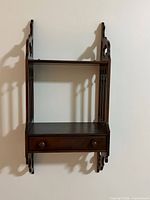 Front view of wall-mounted two-tier wooden shelf with drawer