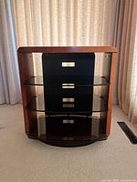 Front view showing wood frame, three glass shelves, back panel openings, swivel base