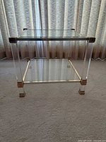 full view of glass and gold-tone end table showing two tiers