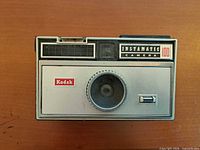 Front view of Kodak Instamatic 100 camera showing lens, branding, and control layout