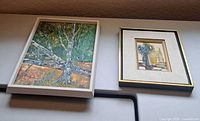 Both framed paintings side by side on shelf