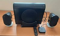 Front view showing subwoofer, two satellites, remote, control console