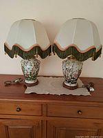 Both lamps with shades, unplugged, on cabinet