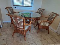 Full view of rattan round table and four matching armchairs