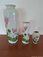 Front view of all three vases showing size comparison and floral design