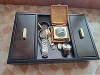 Overall lot showing jewelry box, travel clock, several watches