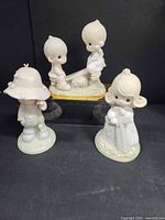 Three Precious Moments figurines group shot